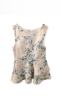 Close-up detail of the layered asymmetrical peplum hem on the beige floral linen blend blouse